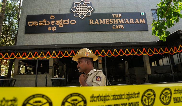 A police official stands guard at the Rameshwaram cafe blast site in Bengaluru